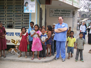 Dennis Tracy posing with some of the children from Bangladesh on his previous trip there.